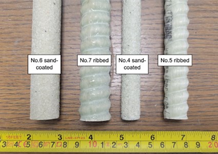 Four sand coated pipes of various sizes on a desk top with a measuring tape at the bottom of the image.