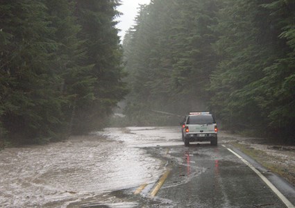 Car approaching flood surge on a rural road