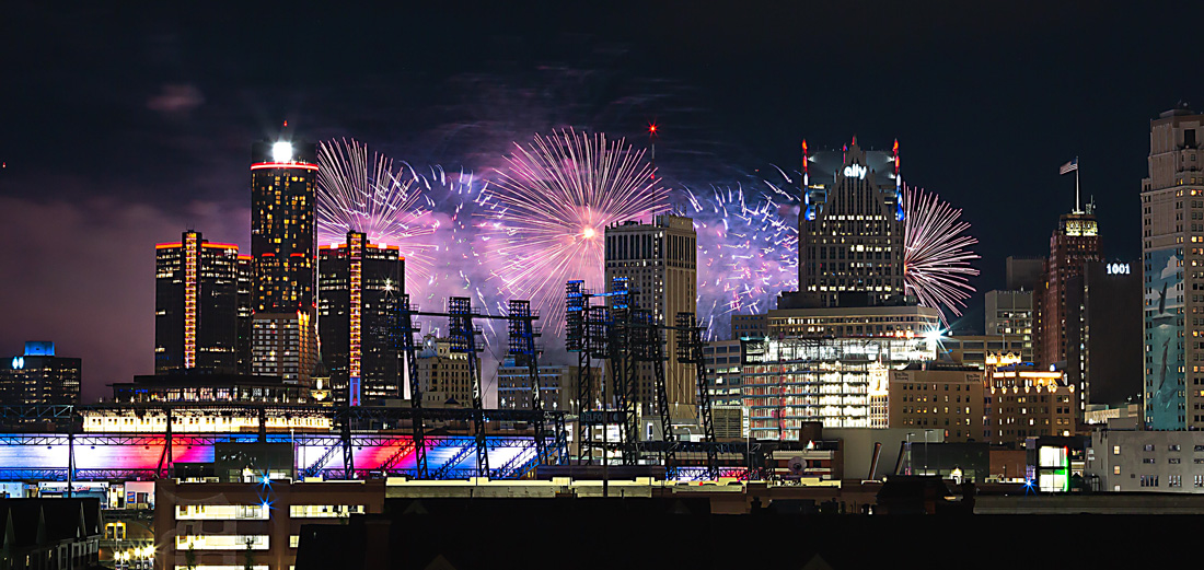 Detroit skyline at night with fireworks in the background.