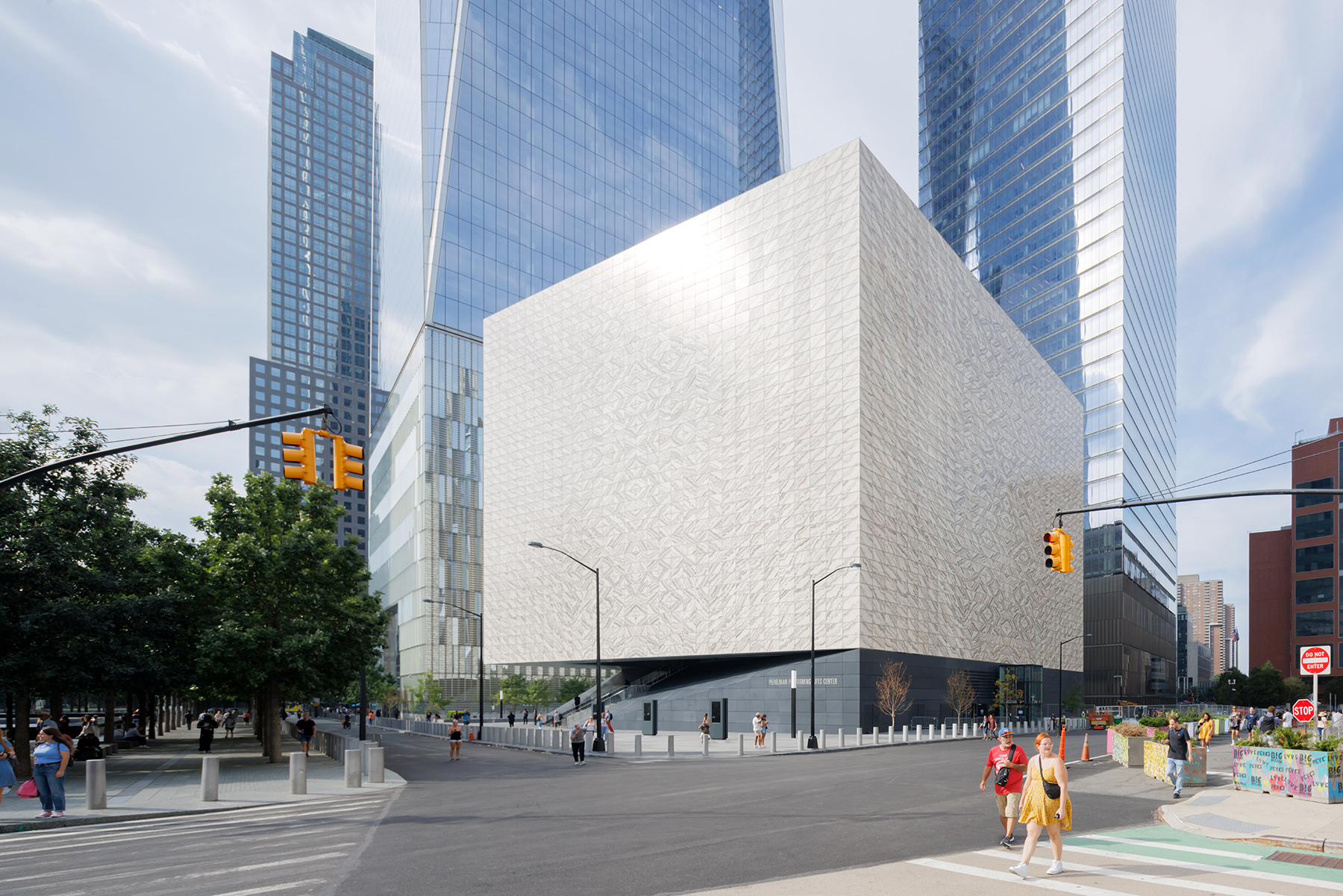 Street view of a light-colored, square building. 