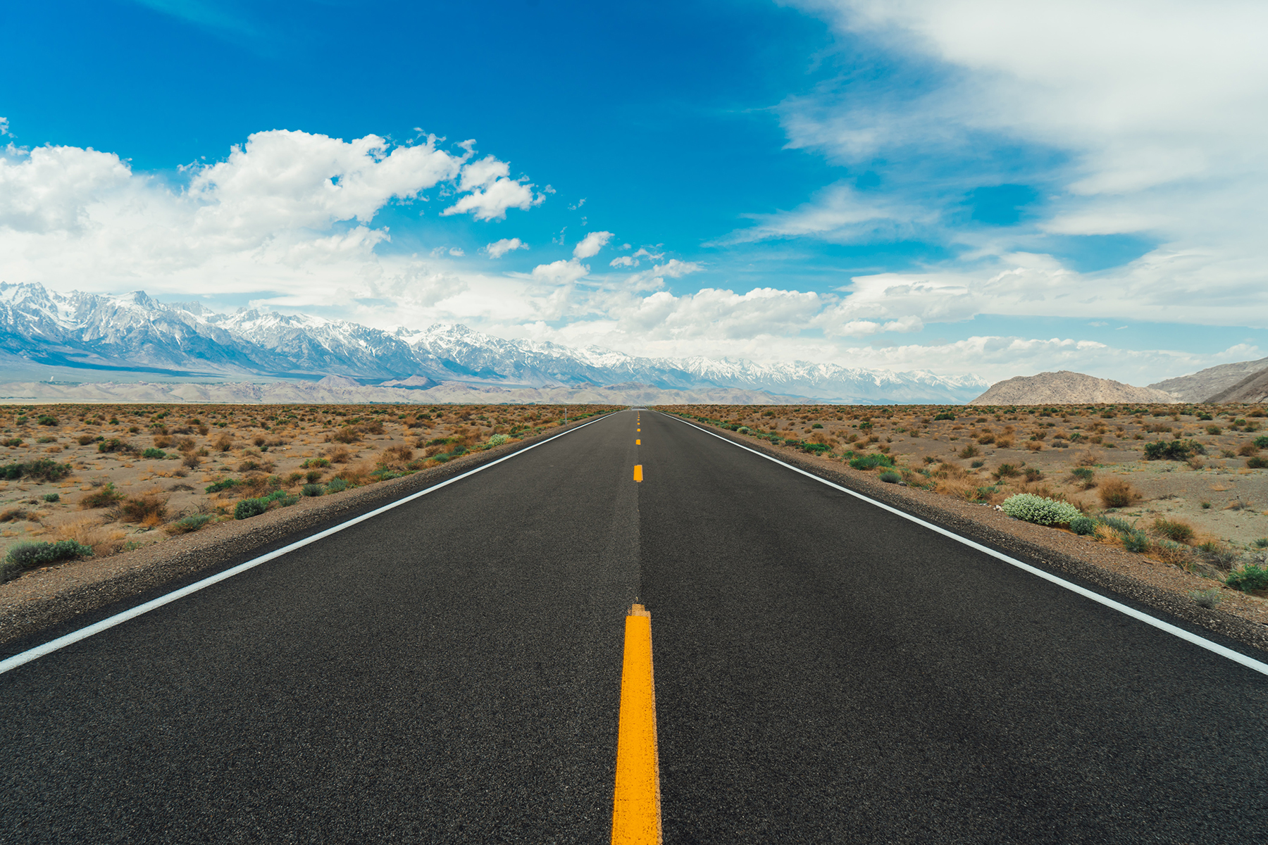 Image shows a divided highway with a barren landscape on the sides.