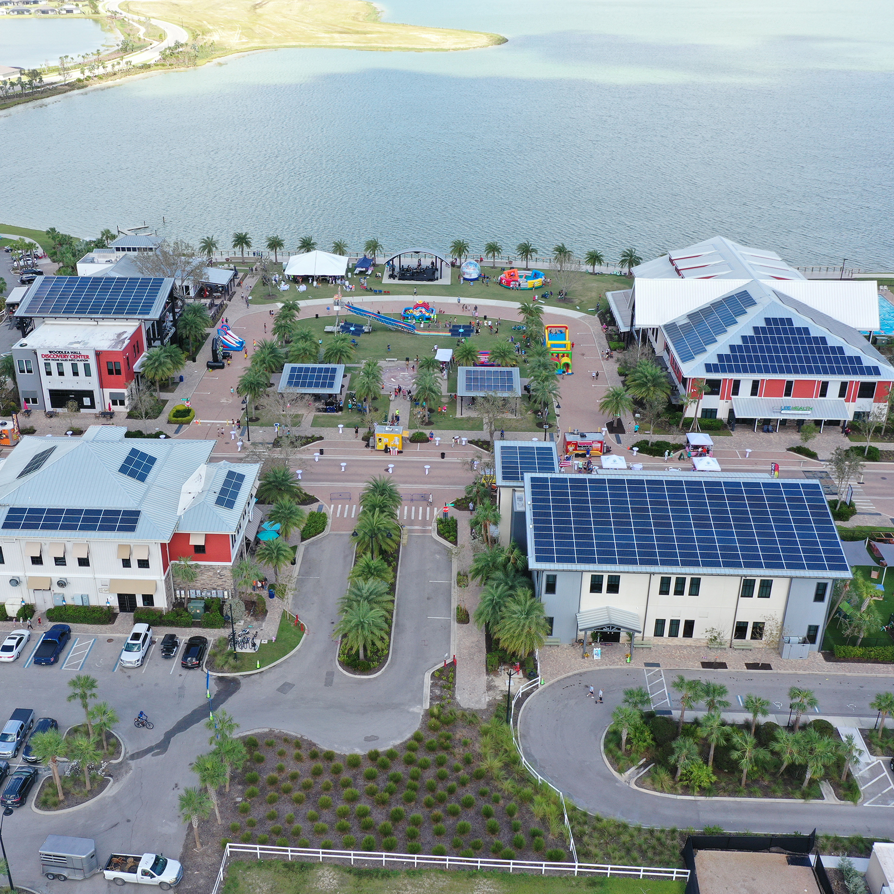 aerial picture of development with solar panels on rooftops and a body of water