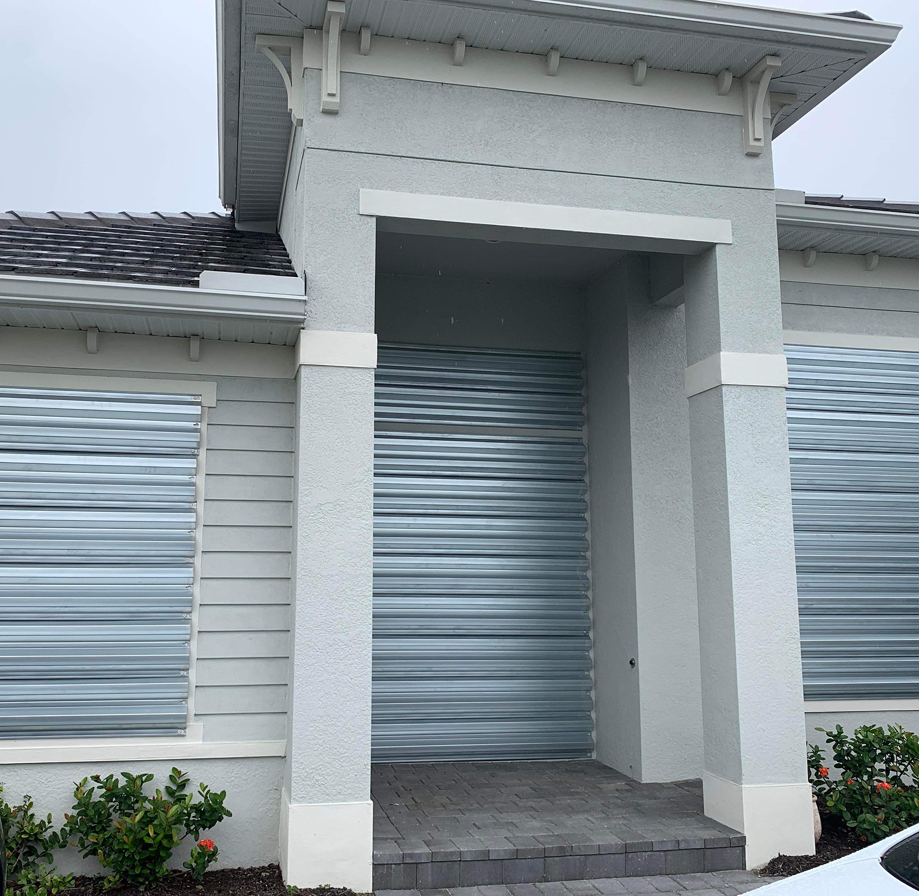 home with windows and door covered by metal shutters