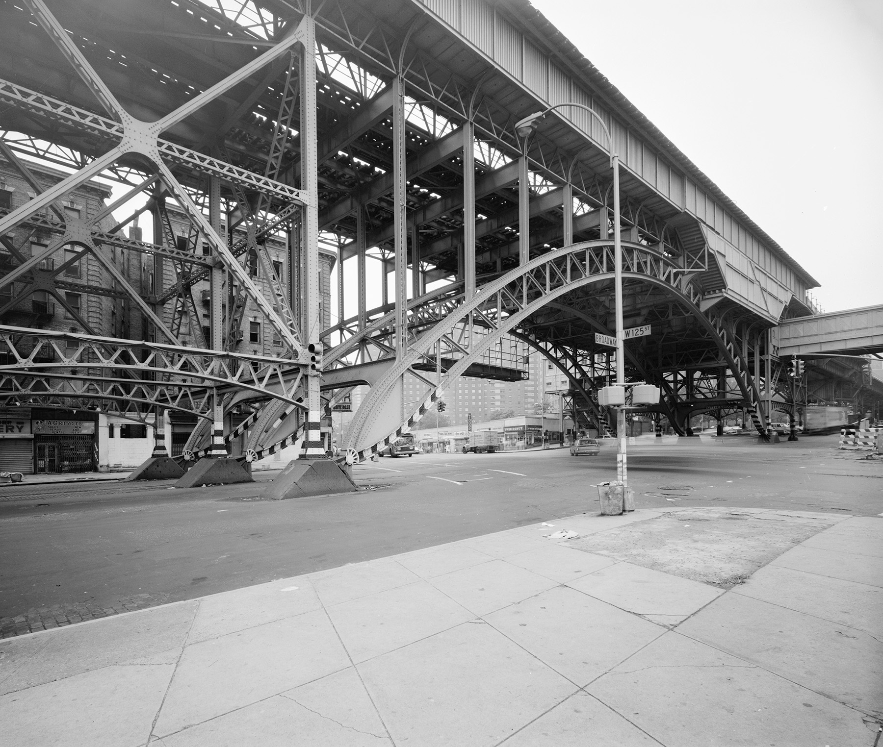Photograph shows the central steel arch span arcing above the street. 
