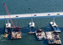 aerial view of cranes in the water working on a bridge