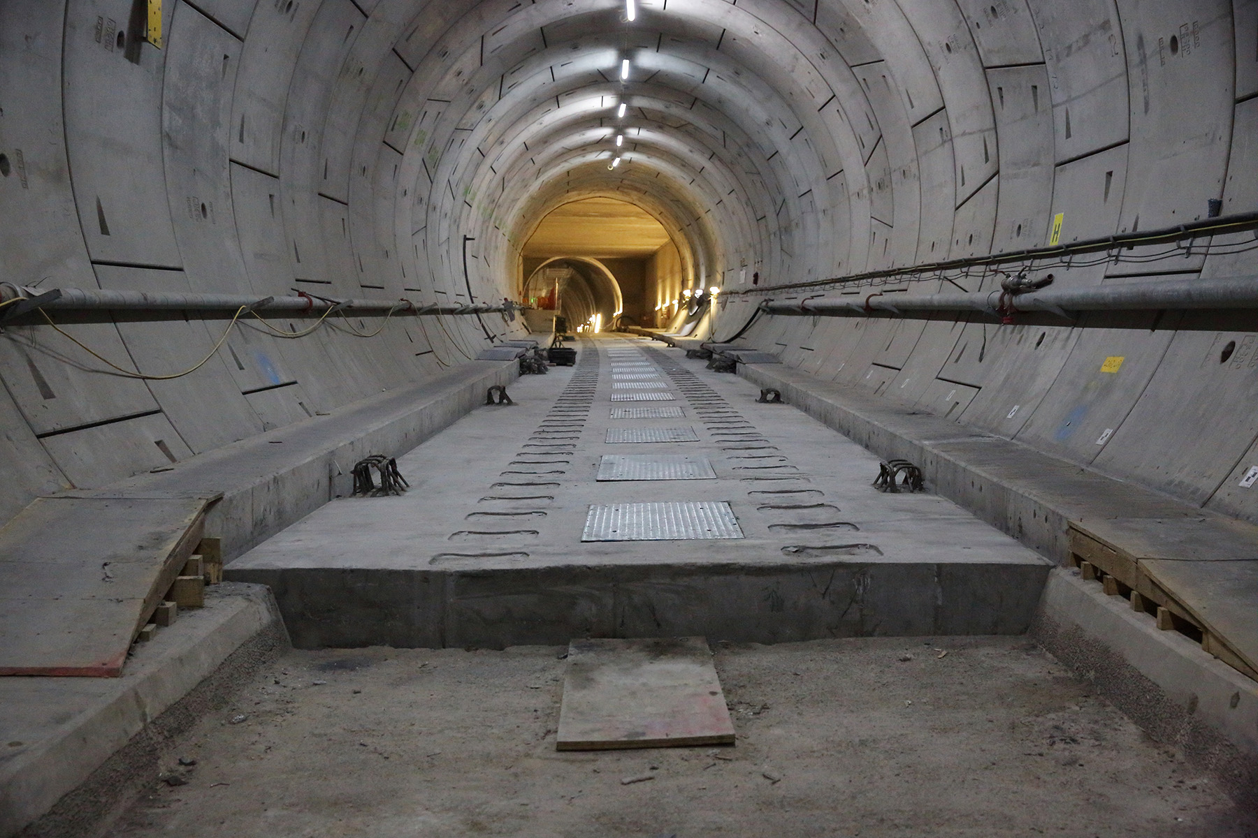 A floating track slab is shown under construction in a tunnel. 