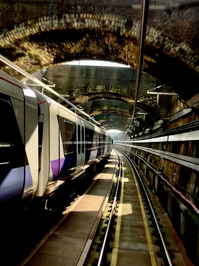 A modern train moves through the brick-lined and restored Victorian-era Connaught Tunnel. 