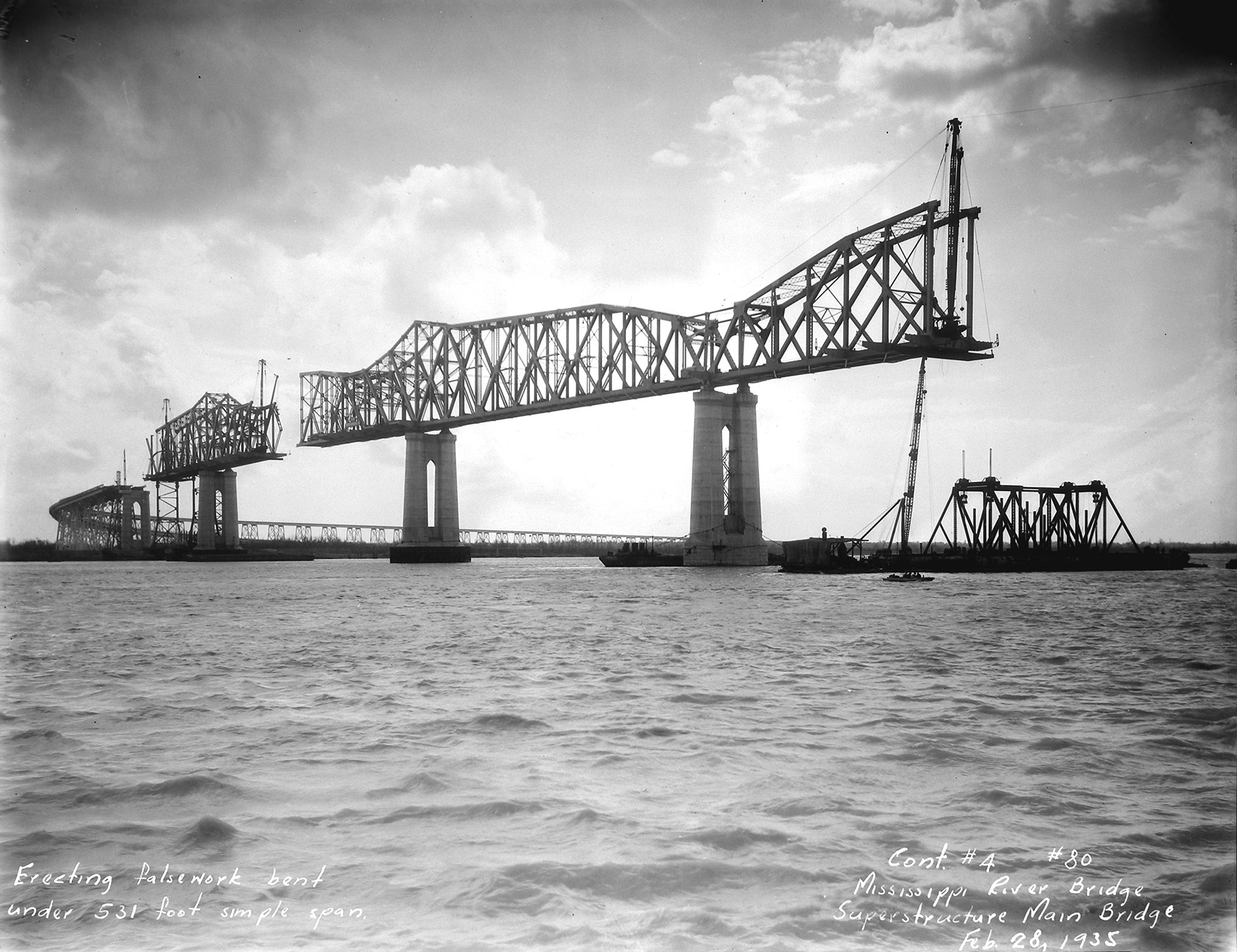 Photo shows a steel bridge being built by the balanced-cantilever method. 