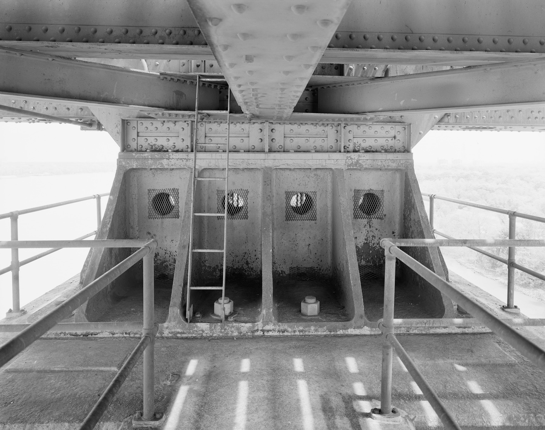 Photo shows an up-close view of the typical support between a bridge span and a concrete pier. 