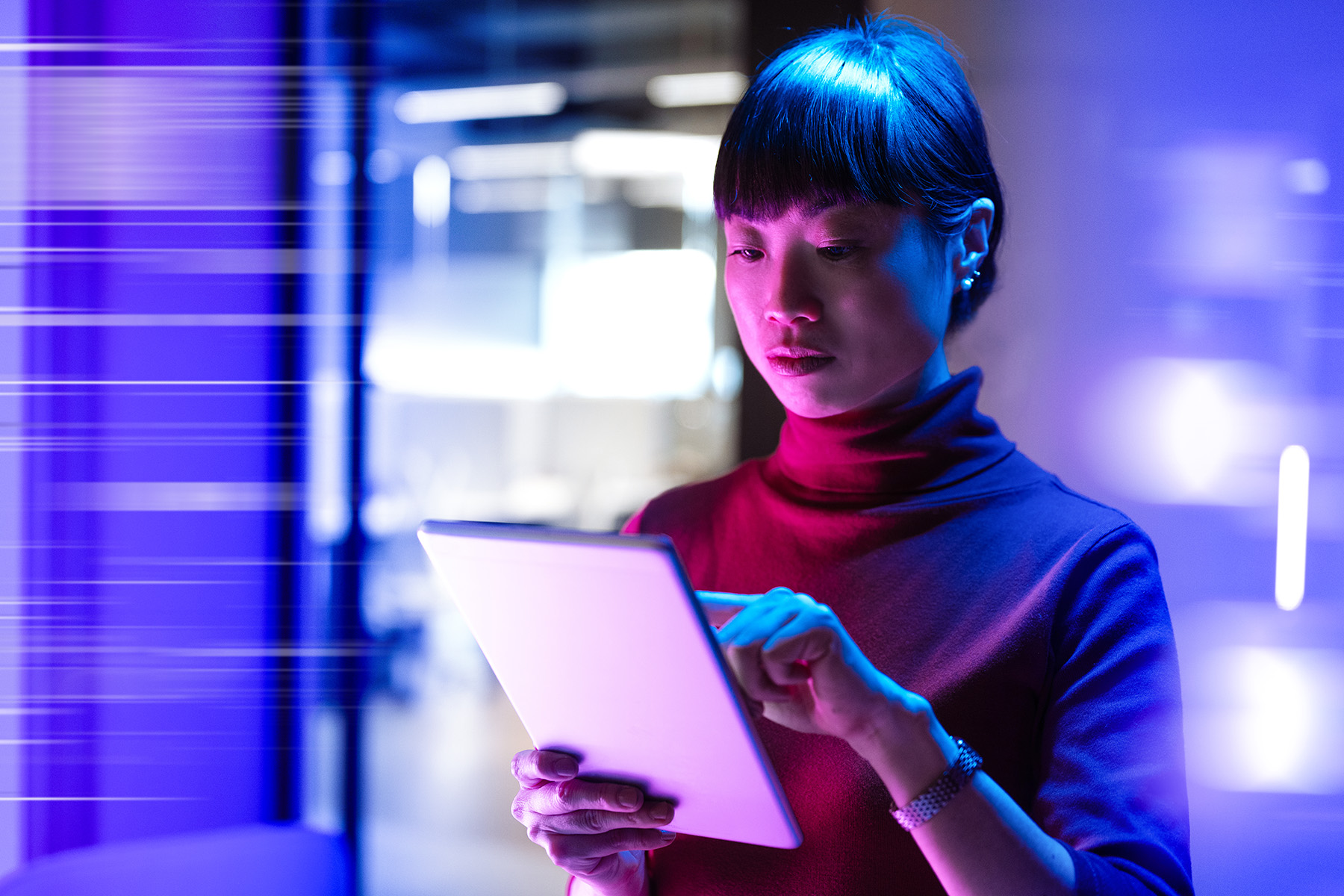 A woman examines an electronic pad device. 