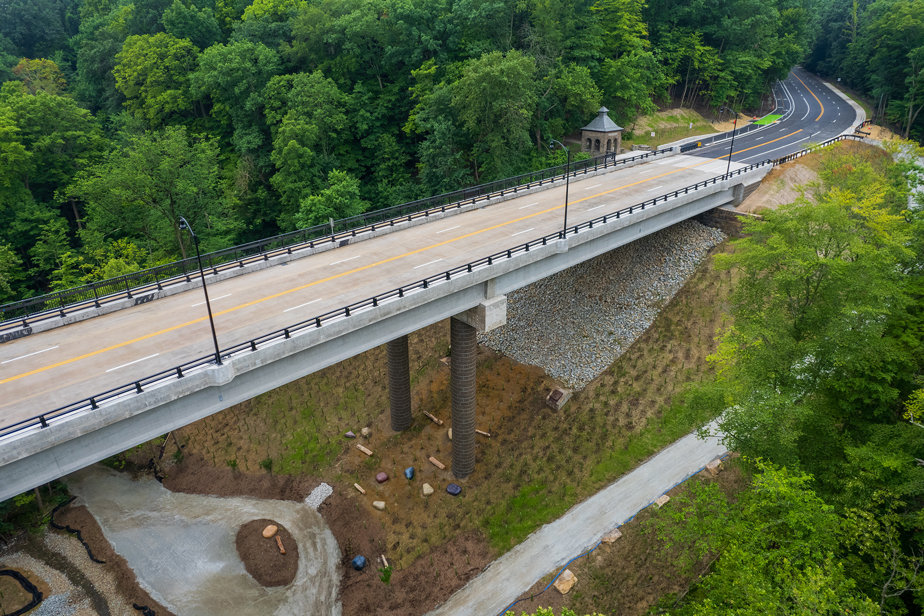 A white bridge with black steel and concrete pedestrian railings. 