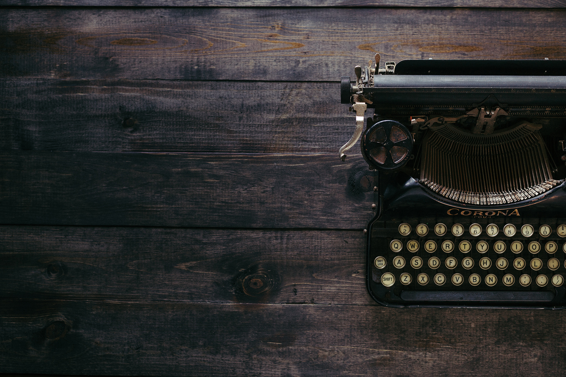 Distressed wooden desk with a typewriter on it.