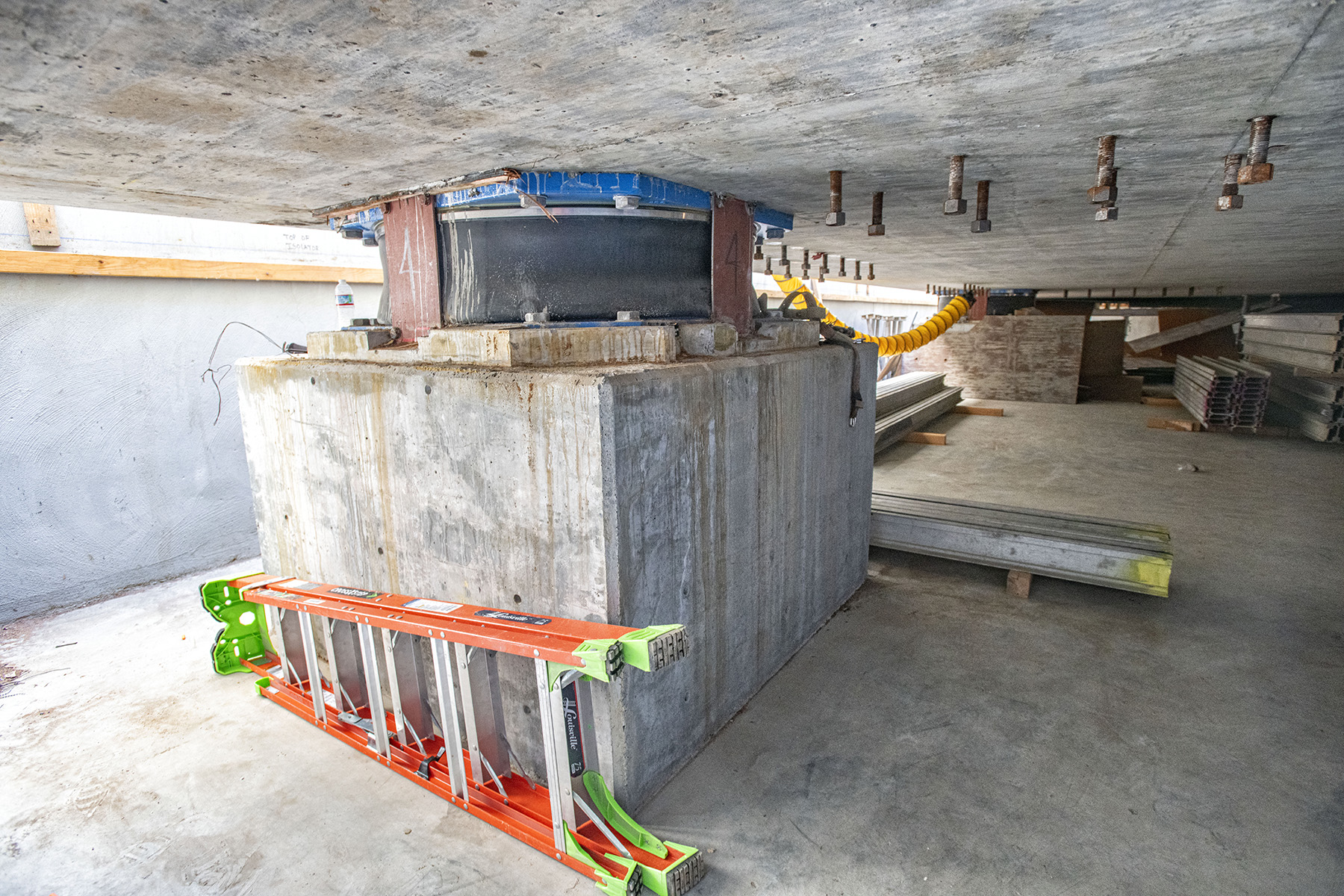 The photo shows one of the seismic isolators beneath the concrete slab on which the shuttle stack will stand. 