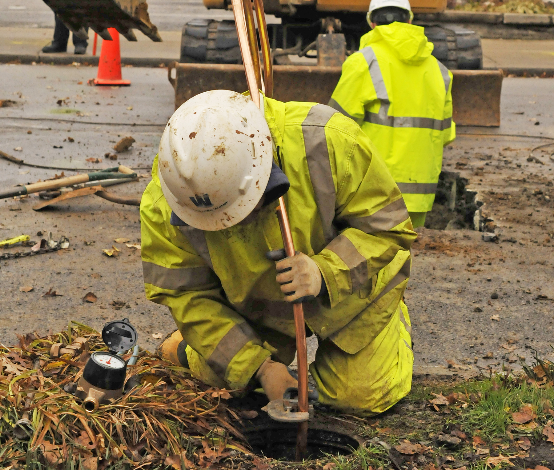 worker on his knees works with pipes