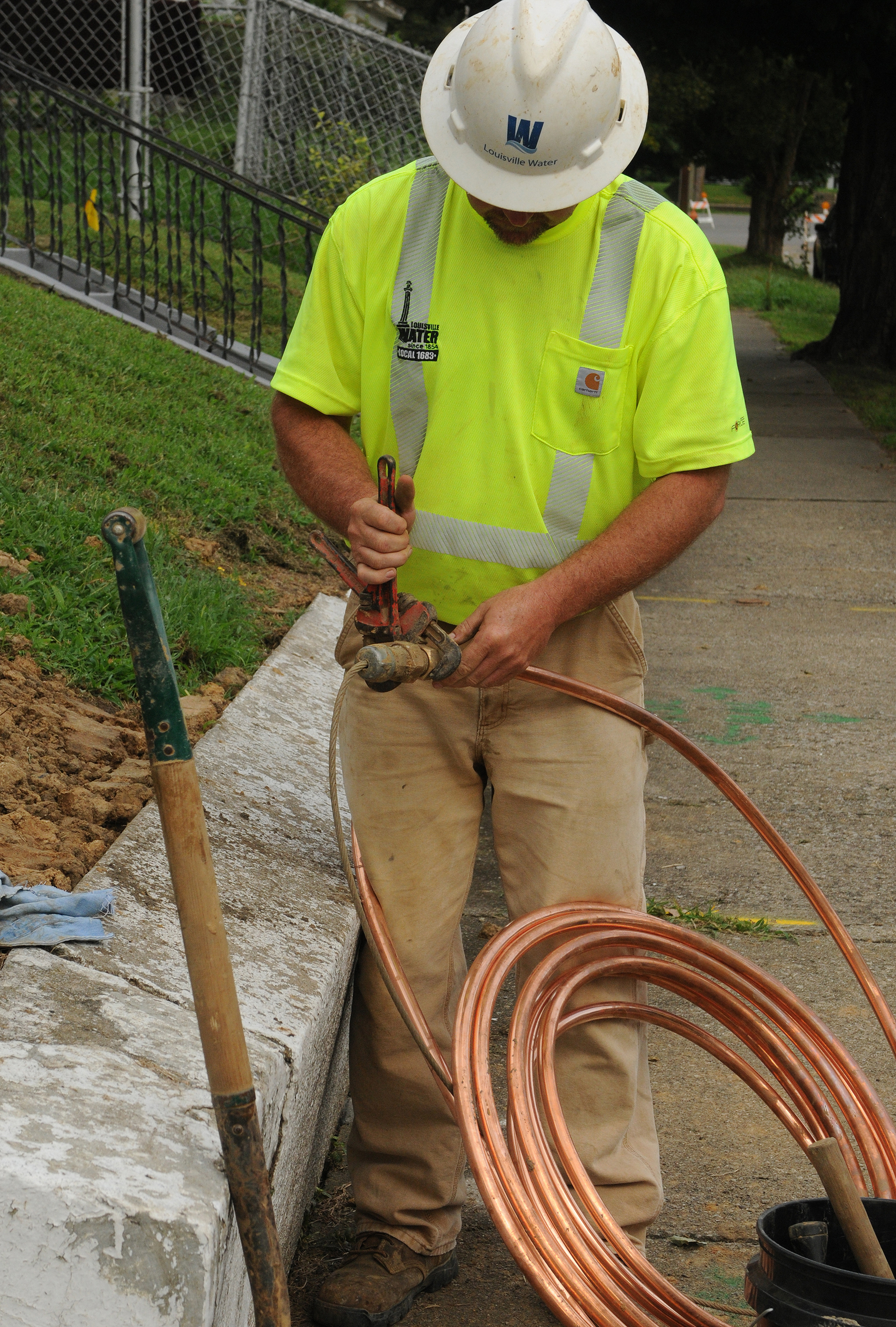 worker with hardhat works with copper piping