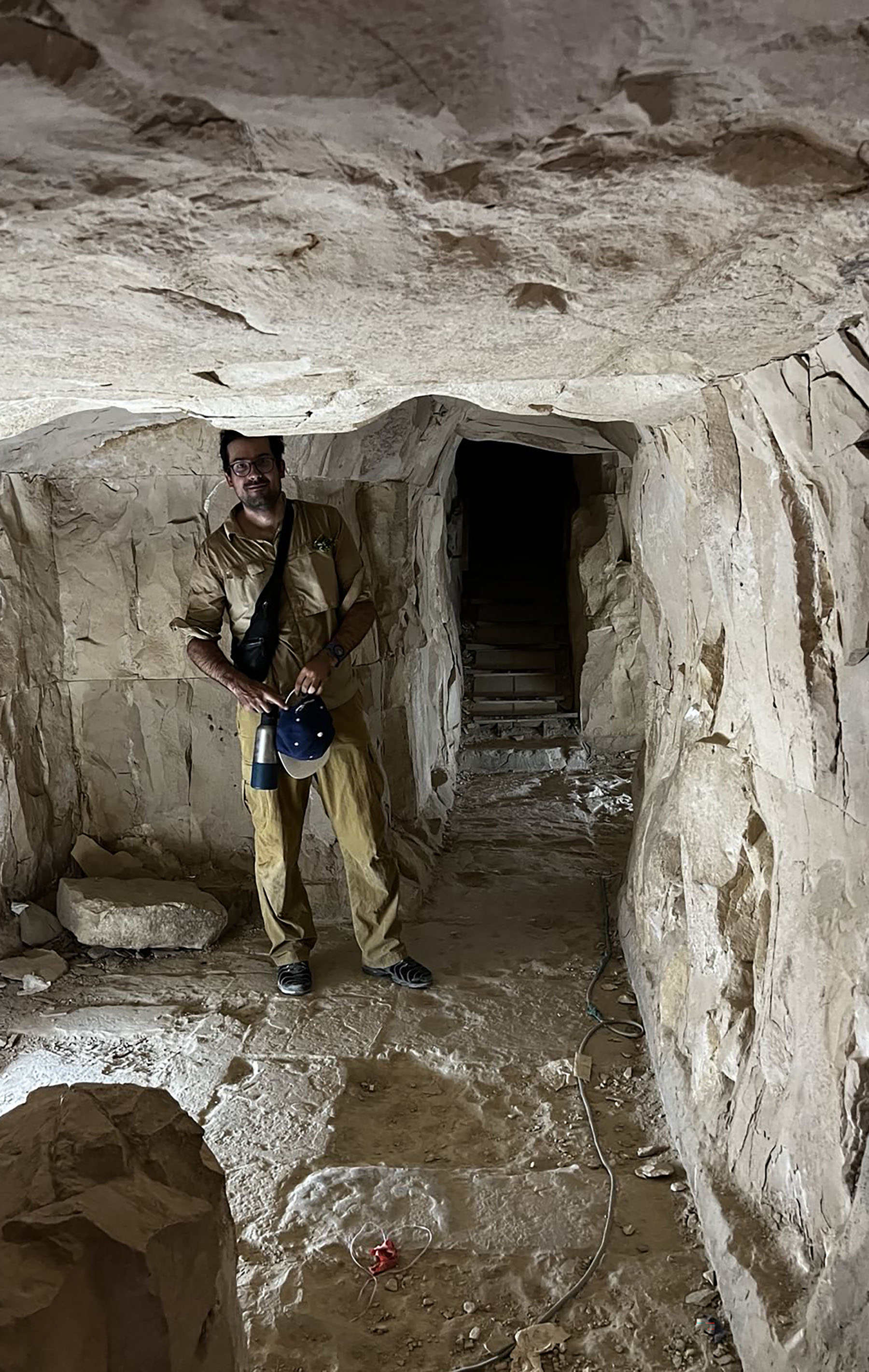 a man stands inside of a pyramid with a low ceiling