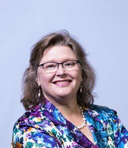 Woman in floral jacket smiling at camera