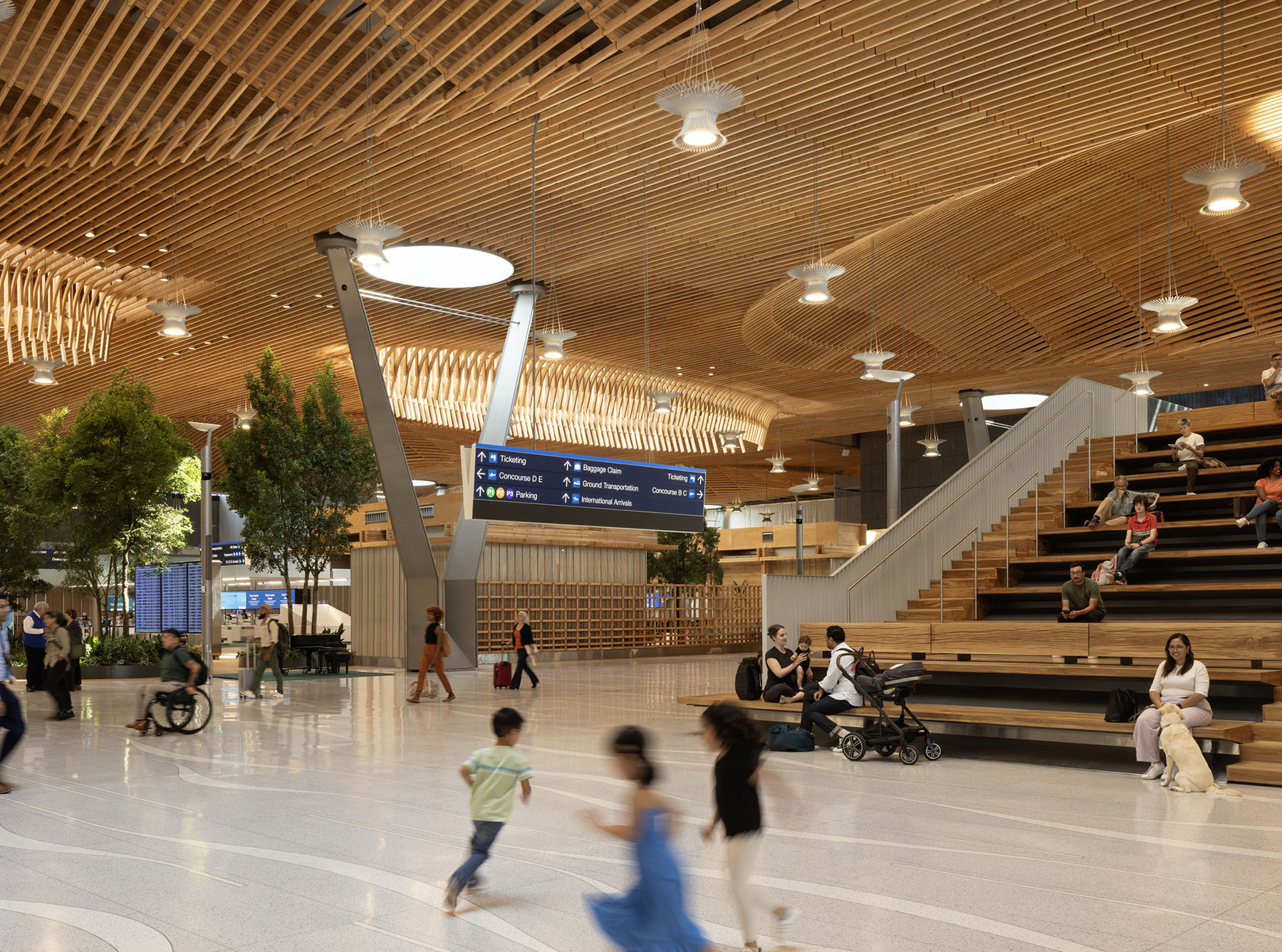children play in an airport terminal featuring a timber roof and a staircase children play in an airport terminal featuring a timber roof and a staircase
