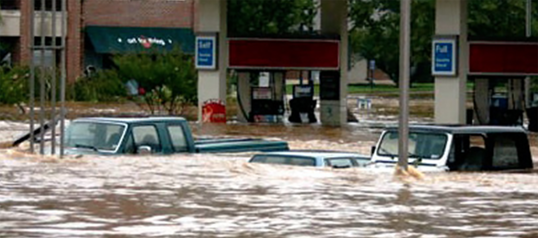 floodwaters leave cars mostly submerged in a gas station