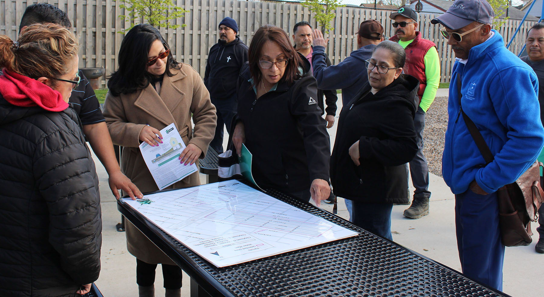 people view a paper on a table in an outdoor environment