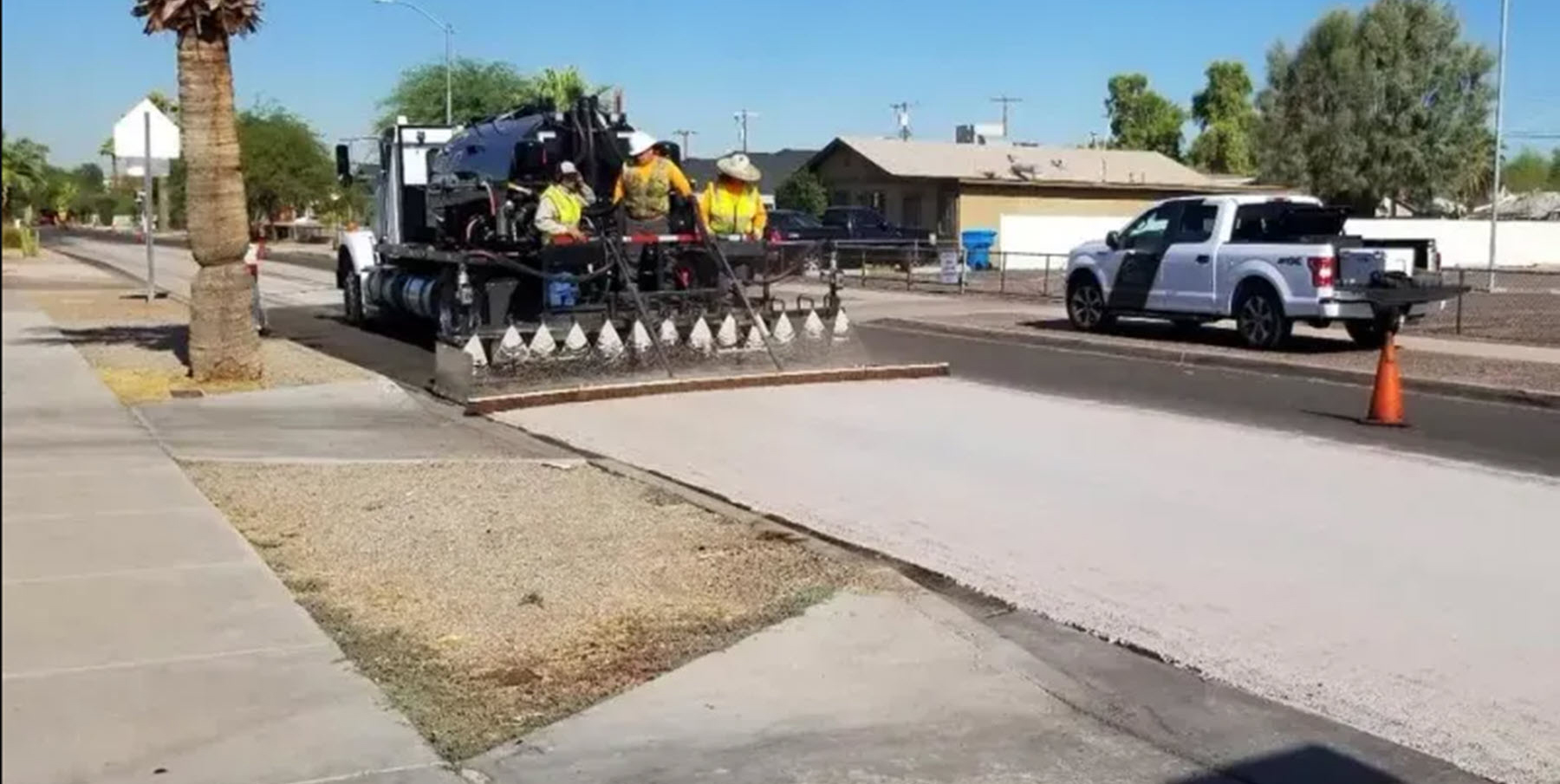 a crew lays cool pavement