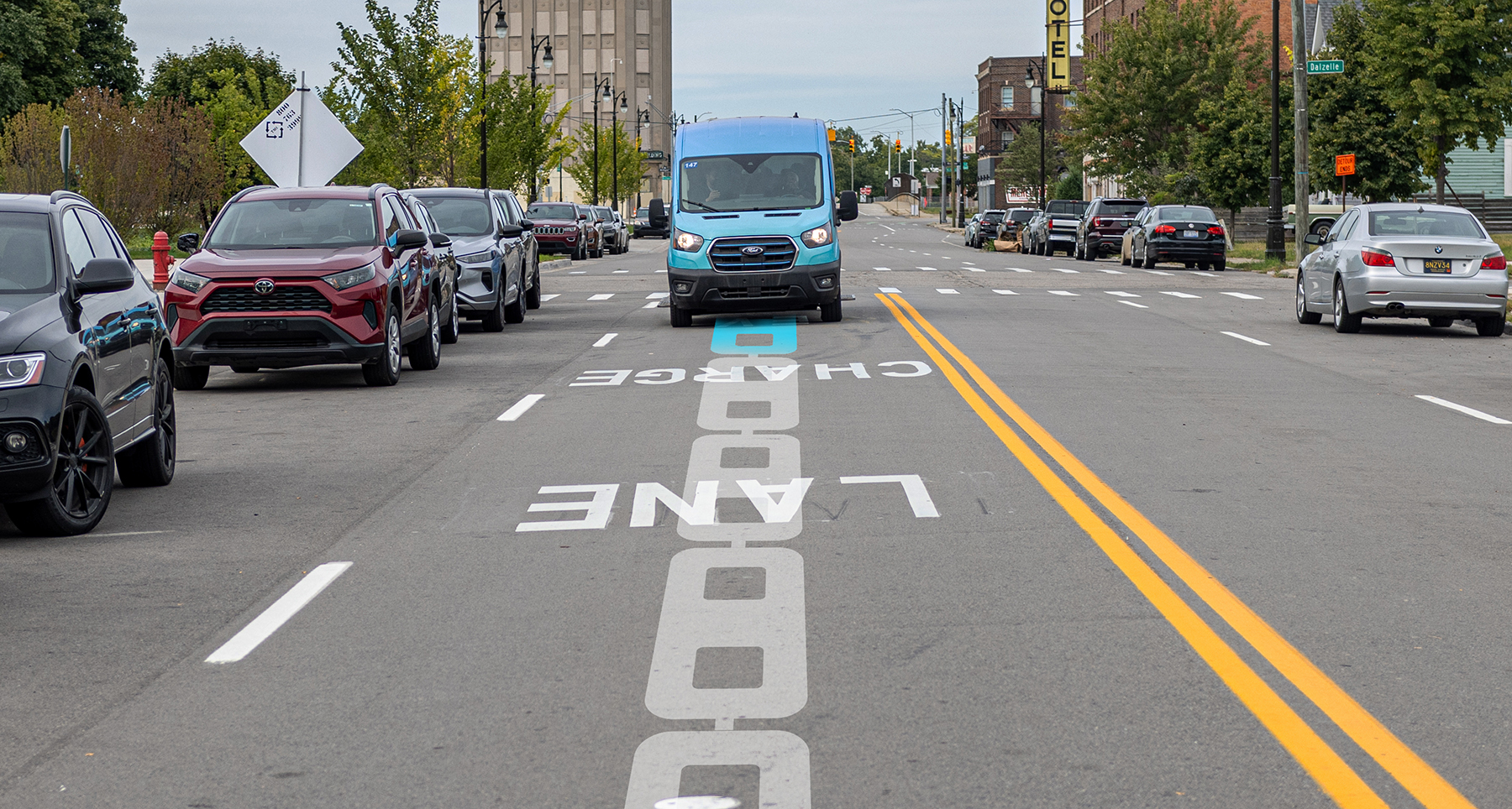 a blue van travels toward the camera on a road